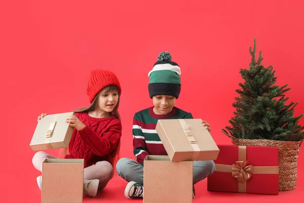 Glada Små Barn Vinter Kläder Öppnar Julklappar Färg Bakgrund — Stockfoto