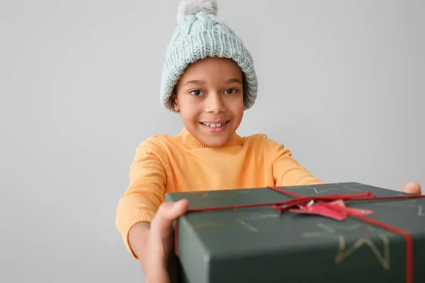 穿着冬衣 头戴灰色背景圣诞礼物的可爱的非洲裔美国小男孩 — 图库照片