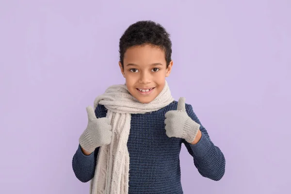穿着冬衣的可爱的非洲裔美国小男孩 在色彩背景上表现出大拇指向上的姿势 — 图库照片