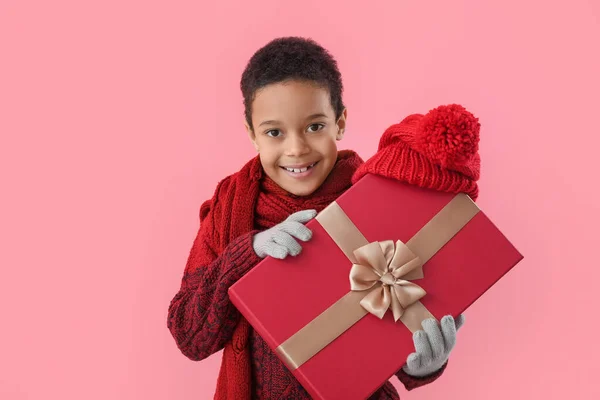 穿着冬衣 头戴彩色背景圣诞礼物的可爱的非洲裔美国小男孩 — 图库照片
