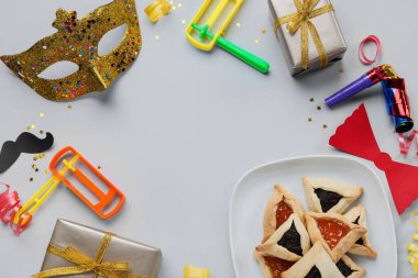 Gri arkaplanda Purim tatili için hamantaschen ve dekordan yapılmış çerçeve