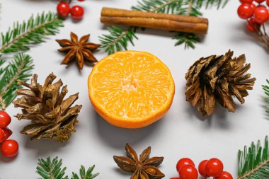 Olgun mandalina, kozalak ve köknar dallarının yarısının beyaz arka planda olduğu kompozisyon, yakın plan.