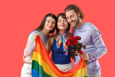 Erkek ve iki güzel kadın gökkuşağı bayrağı ve renkli arka planda çiçekler. Çokeşlilik ve LGBT kavramı