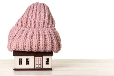 Beyaz arka planda pembe şapkalı ev modeli. Isıtma kavramı