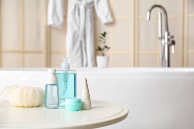 Sünger ve kozmetik ürünleri banyodaki masada.