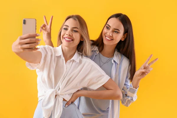 Giovani Donne Con Cellulare Scattare Selfie Sfondo Giallo — Foto Stock