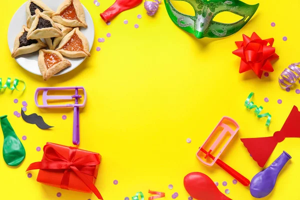 Sarı arka planda Purim tatili için hamantaschen ve dekordan yapılmış çerçeve
