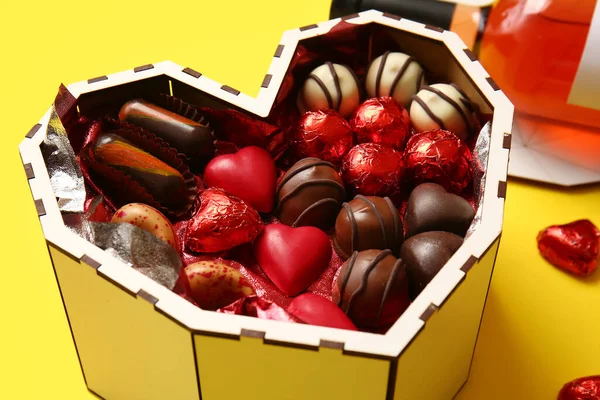 Pudełko Kształcie Serca Smacznymi Czekoladowymi Cukierkami Żółtym Tle Zbliżenie — Zdjęcie stockowe