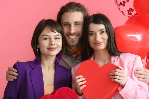 男人和两个漂亮的女人带着彩色背景的情人节礼物 一夫多妻制的概念 — 图库照片