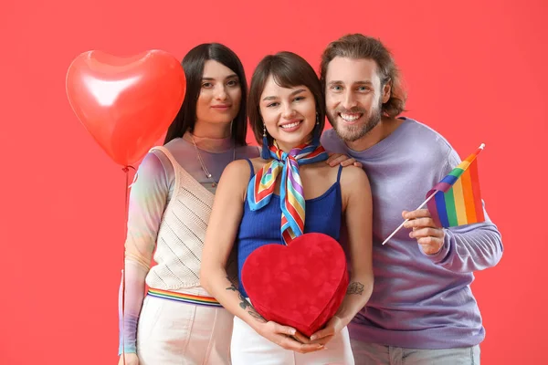 男人和两个漂亮的女人带着彩虹旗 礼物和气球的色彩背景 一夫多妻制和男女同性恋 双性恋和变性者的概念 — 图库照片