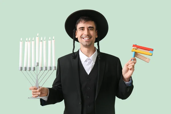 Judisk Man Med Purim Skallra Och Menorah Färg Bakgrund — Stockfoto