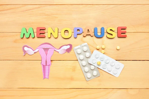 Word Menopause Paper Uterus Pills Light Wooden Background — Stock Photo, Image