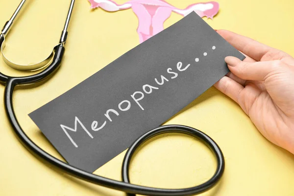 Woman Holding Paper Word Menopause Stethoscope Uterus Yellow Background Closeup — Stock Photo, Image
