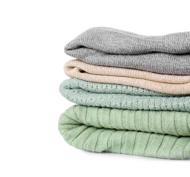 Beyaz arkaplanda katlanmış süveter yığını, yakın plan