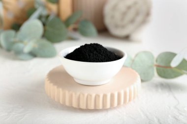 Masanın üzerinde aktif kömür dişi tozu olan bir kase.