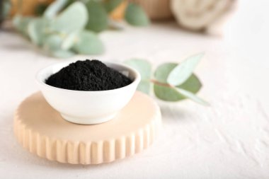 Beyaz arkaplanda aktif kömür diş tozu olan kase