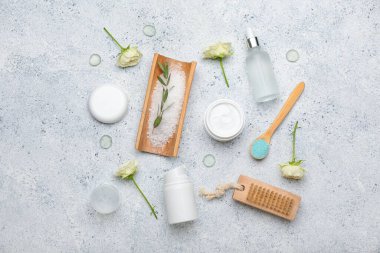 Işıklı arka planda farklı kozmetik ürünleri ve gül çiçekleri