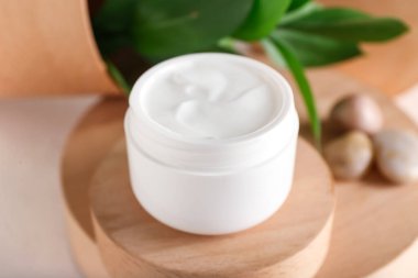 Hafif arka planda doğal kozmetik kremi olan kavanoz, yakın plan.