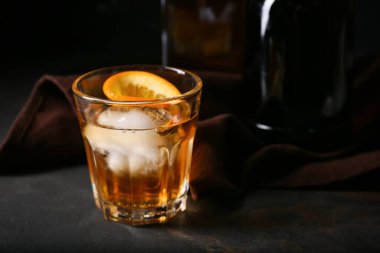 Bir bardak lezzetli siyah arka planda eski moda kokteyl.