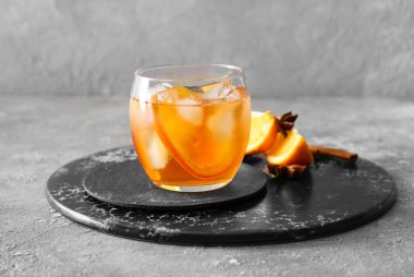 Bir bardak lezzetli, gri arka planda eski moda kokteyl.