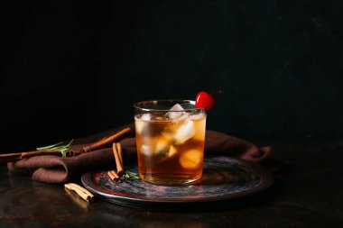 Bir bardak lezzetli siyah arka planda eski moda kokteyl.