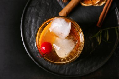 Bir bardak lezzetli siyah arka planda eski moda kokteyl.