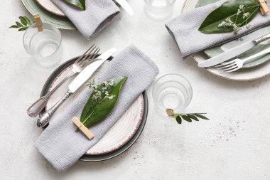 Açık arkaplanda çiçek dekoru olan zarif masa ayarı