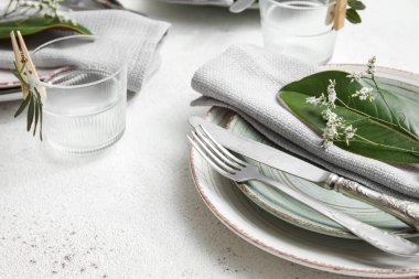 Açık arkaplanda çiçek dekoru olan zarif masa ayarı