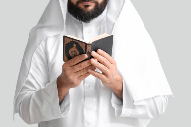 Kuran okuyan Müslüman adam arka planda dua ediyor