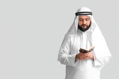 Kuran okuyan Müslüman adam arka planda dua ediyor