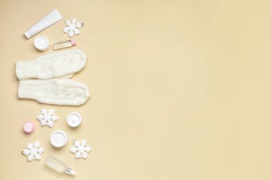 Renkli arka planda kozmetik ürünleri, eldivenler ve kar taneleri ile kompozisyon