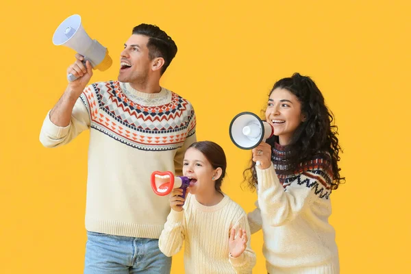 Ouders Met Kleine Dochter Warme Truien Schreeuwen Megafoons Gele Achtergrond — Stockfoto