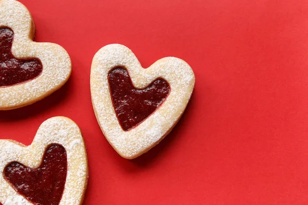 赤い背景にハート型のおいしいクッキー — ストック写真