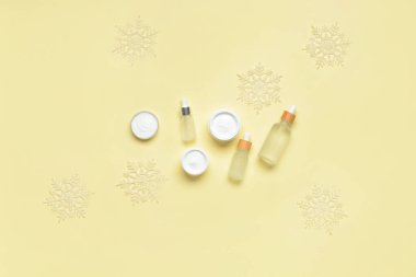 Farklı kozmetik ürünleri ve renk arkaplan üzerinde güzel kar taneleri olan kompozisyon