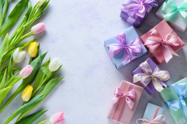 Uluslararası Kadınlar Günü için açık arkaplanda güzel lale çiçekleri ve hediye kutuları