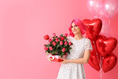 Parlak saçlı şık bir kadın, bir buket çiçek ve renkli balonlar. Sevgililer Günü kutlaması