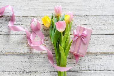 Uluslararası Kadınlar Günü için açık ahşap arka planda hediye kutusu ve çiçek içeren kompozisyon