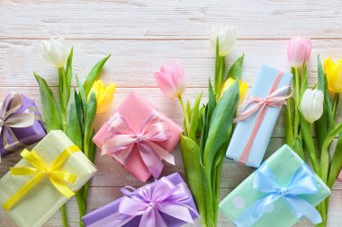 Uluslararası Kadınlar Günü için açık ahşap arka planda hediye kutlaması ve çiçeklerle birlikte kompozisyon