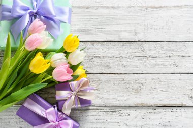 Uluslararası Kadınlar Günü için açık ahşap arka planda hediye kutlaması ve çiçeklerle birlikte kompozisyon