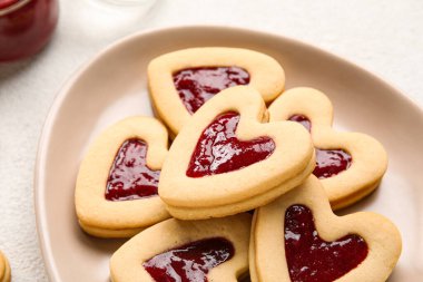 Sevgililer Günü kutlaması için tatlı kurabiyelerle dolu tabak arka planda, yakın plan.