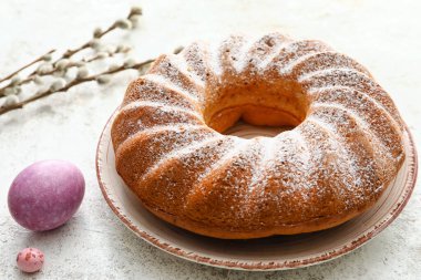 Lezzetli Paskalya pastası ve açık arkaplanda yumurta tabağı.