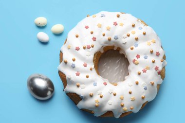 Lezzetli Paskalya pastası ve mavi arka planda yumurta tabağı.