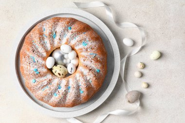 Lezzetli Paskalya pastası ve açık arkaplanda yumurta tabağı.