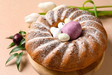 Lezzetli Paskalya pastası ve bej arka planda yumurtaları olan ahşap tahta tahta.