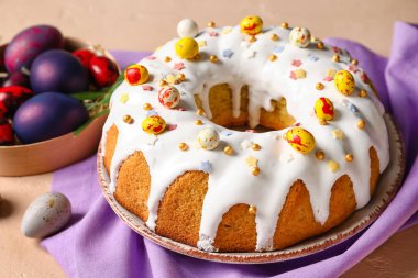 Lezzetli Paskalya pastası ve bej arka planda yumurta tabağı.