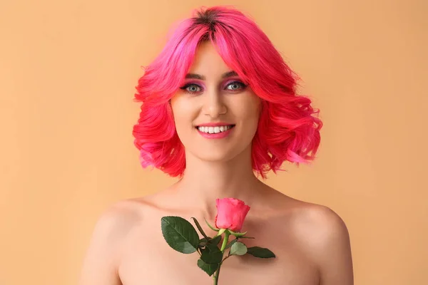 明るい髪と色の背景にバラの花を持つスタイリッシュな女性 — ストック写真