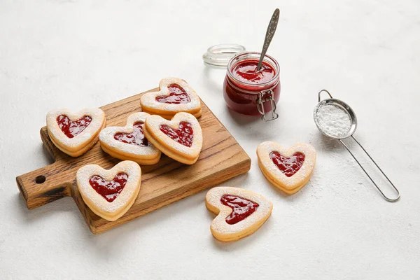 光の背景でバレンタインデーのお祝いのためのおいしいクッキーとジャムでボード — ストック写真