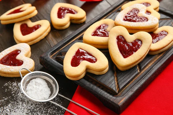 暗い木製の背景にバレンタインデーのお祝いのためのおいしいクッキーとジャムでボード クローズアップ — ストック写真