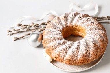 Lezzetli Paskalya pastası, söğüt dalları ve açık arkaplanda yumurtalar.