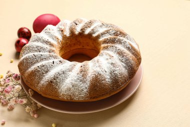 Lezzetli Paskalya pastası ve bej arka planda çigila çiçekli tabak.